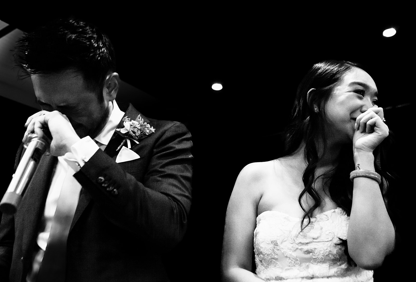 Bride and groom crying on stage after speech