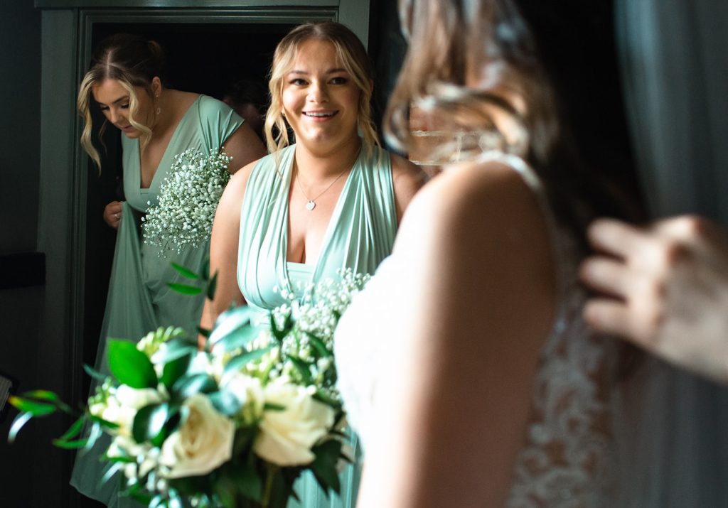 Bridesmaid reaction to bride in her wedding dress