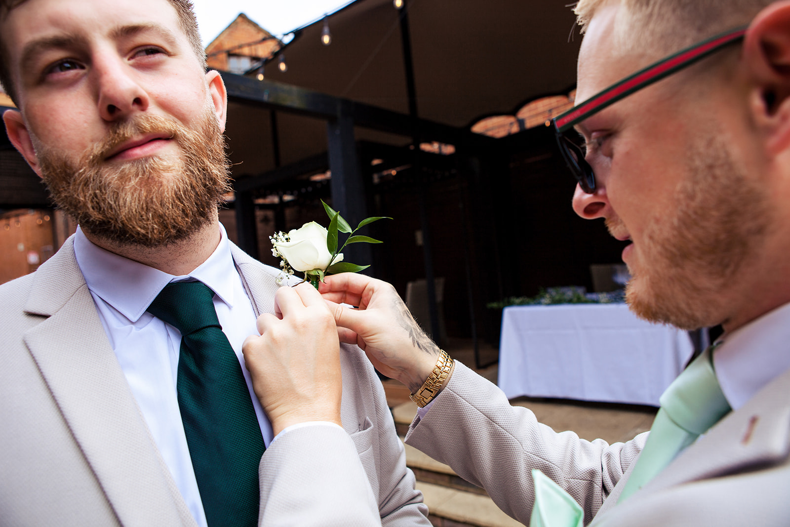 Flower being pinned on groom's suit